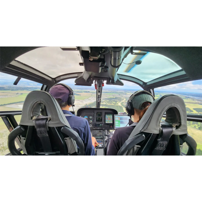 A woman and a man flying in a helicopter.