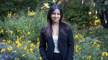 Michelle Gil Munoz wearing black blazer against greenery backdrop.